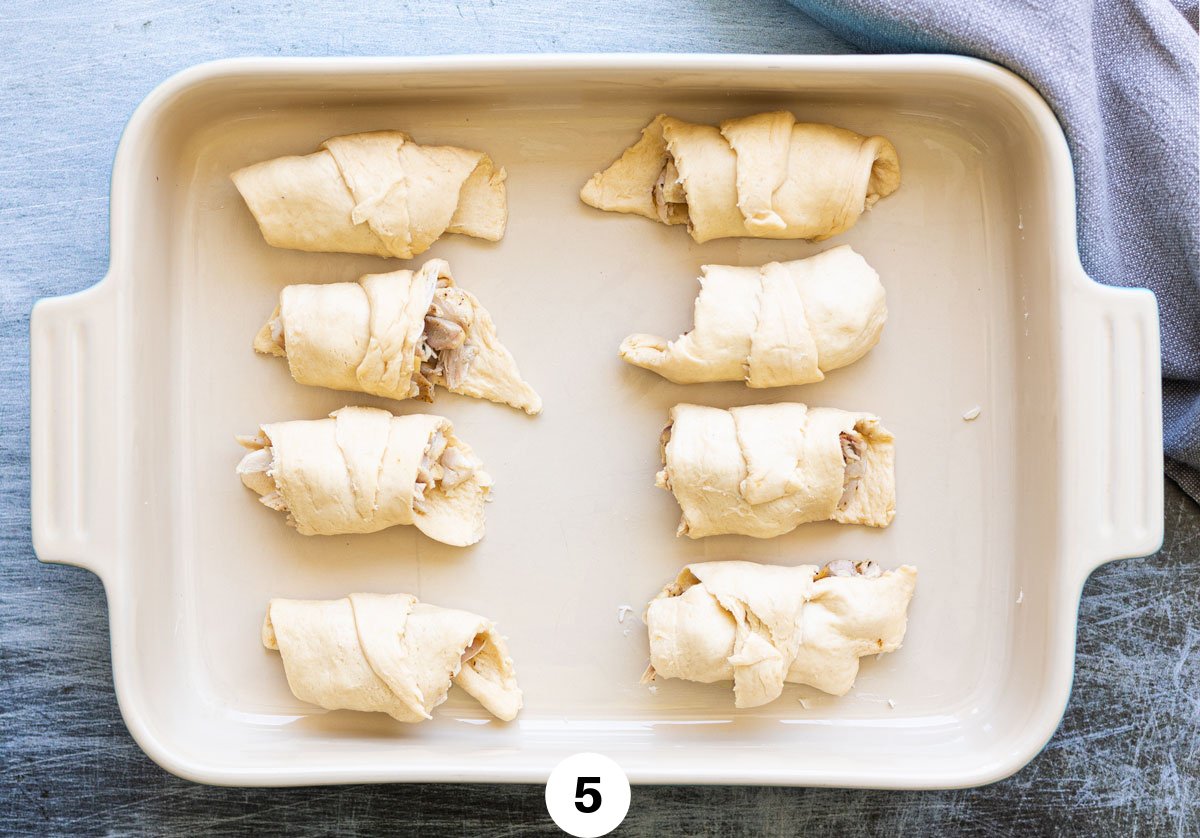 chicken filled crescent rolls evenly spaced in a baking dish. 