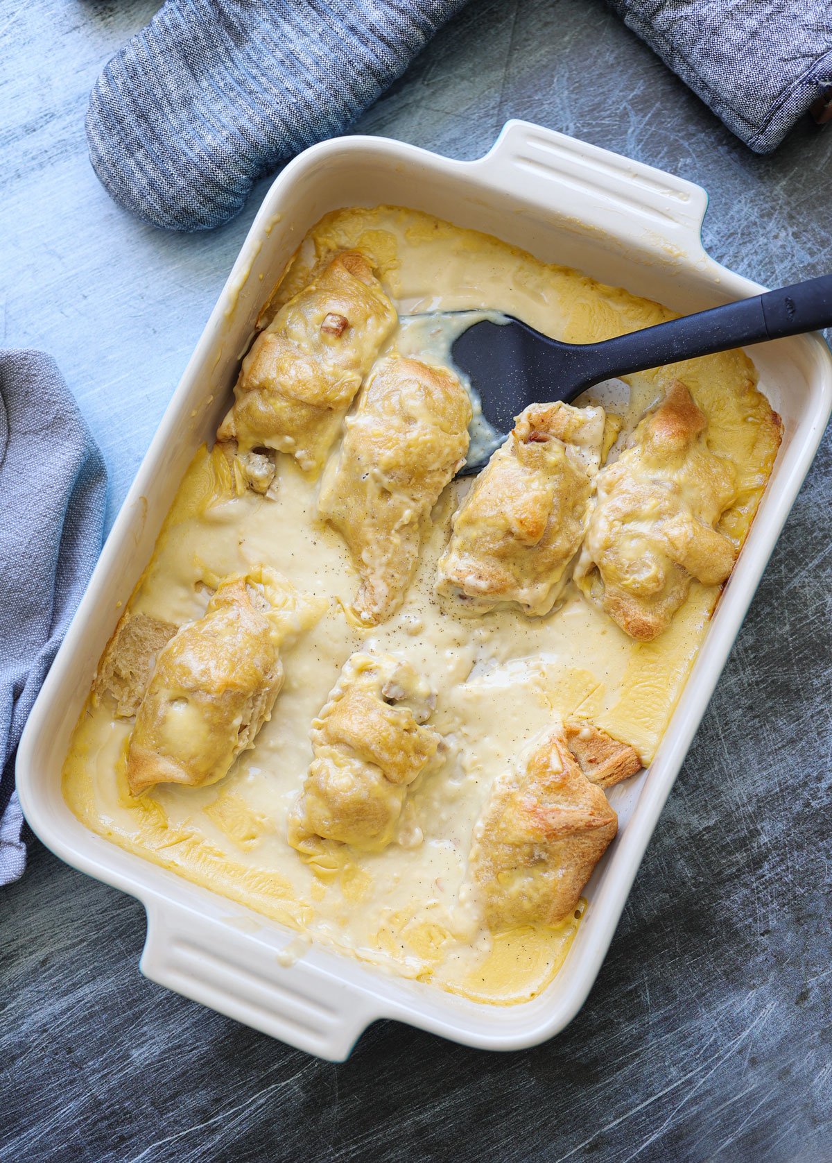 Casserole dish filled with crescent rolls topped with sauce.