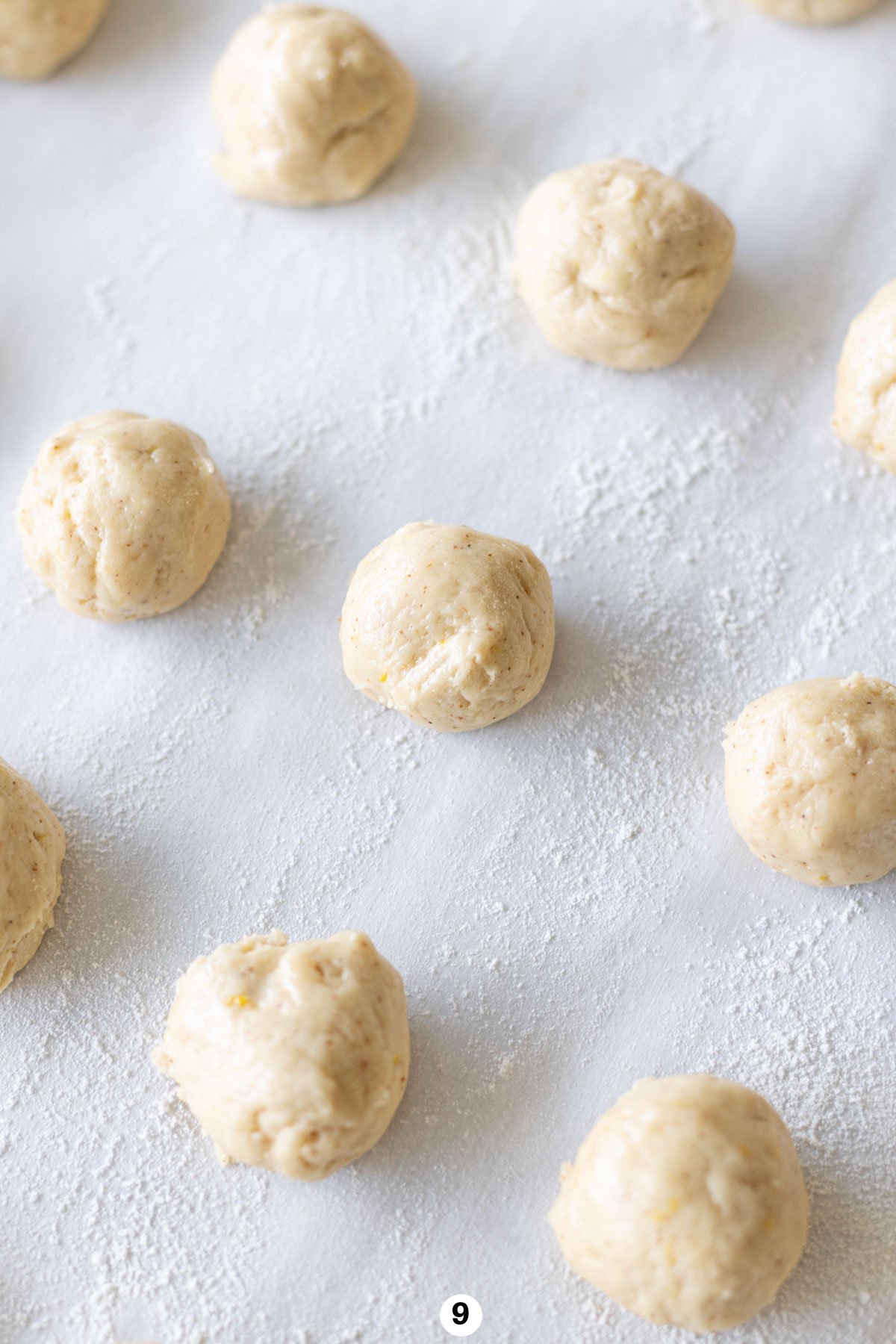 Rolling the anise cookie dough into small balls and lining them up on the pan. 