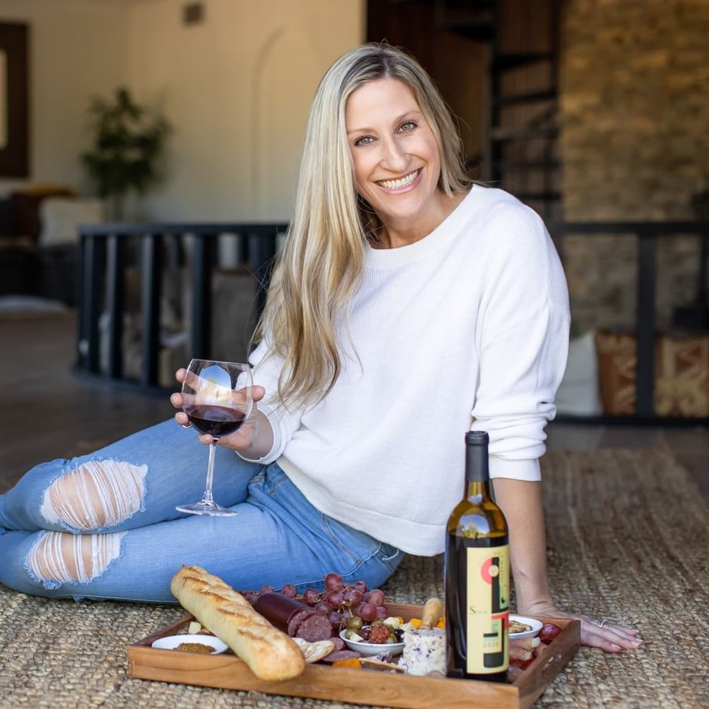 picture of amanda on the ground with a great tasting spread of food and wine