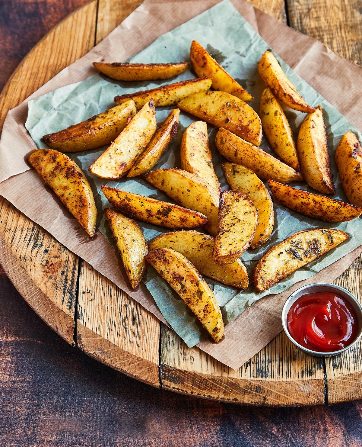 Crispy steak french fries on a parchment paper lined serving tray, served with ketchup. 