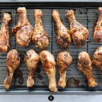 Chicken legs being cooked on a rack.