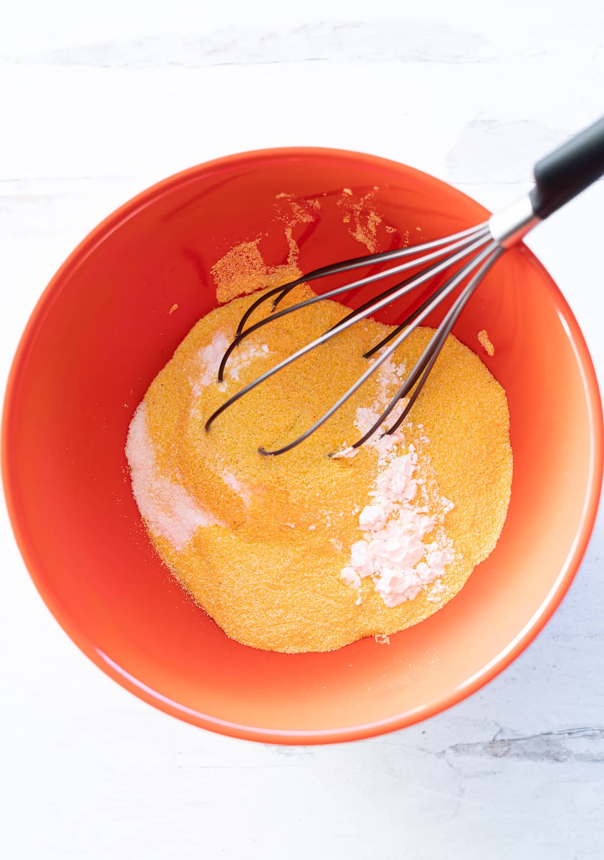 Bowl filled with dry ingredients to make cornbread.