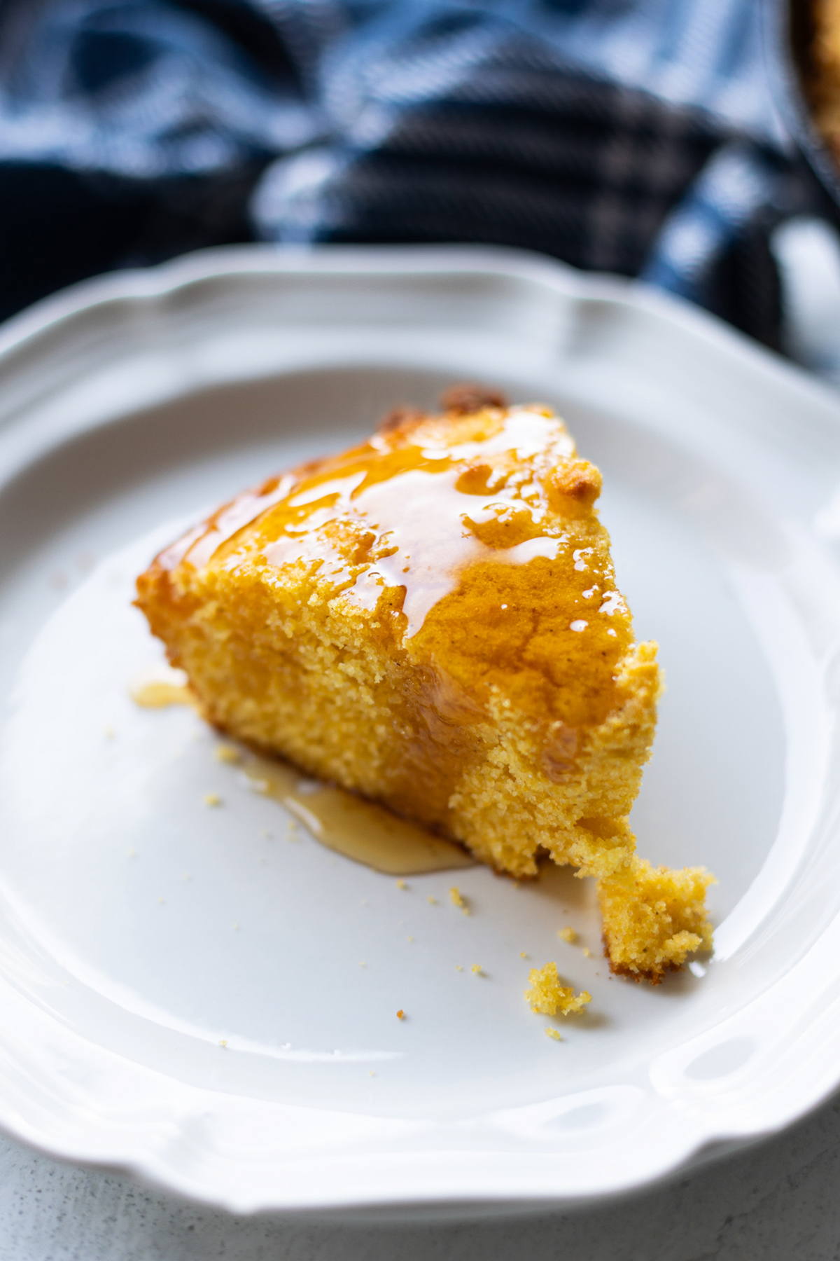 Cornbread on a plate covered in honey. 