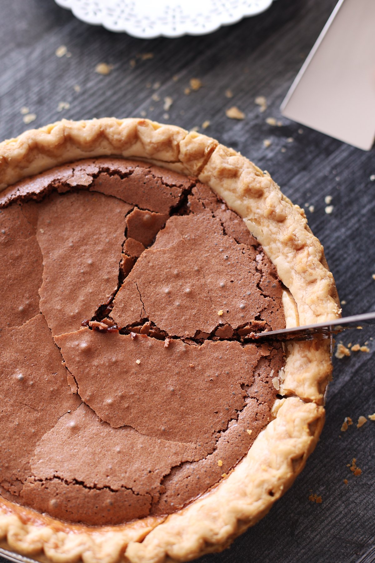 Person slicing a chocolate pie.