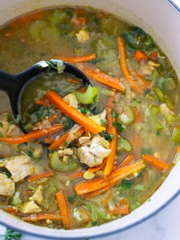 Person serving detox soup out of a pot.