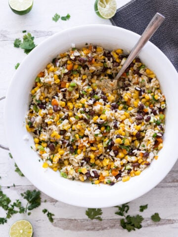 Big bowl of black bean and corn salad being served.