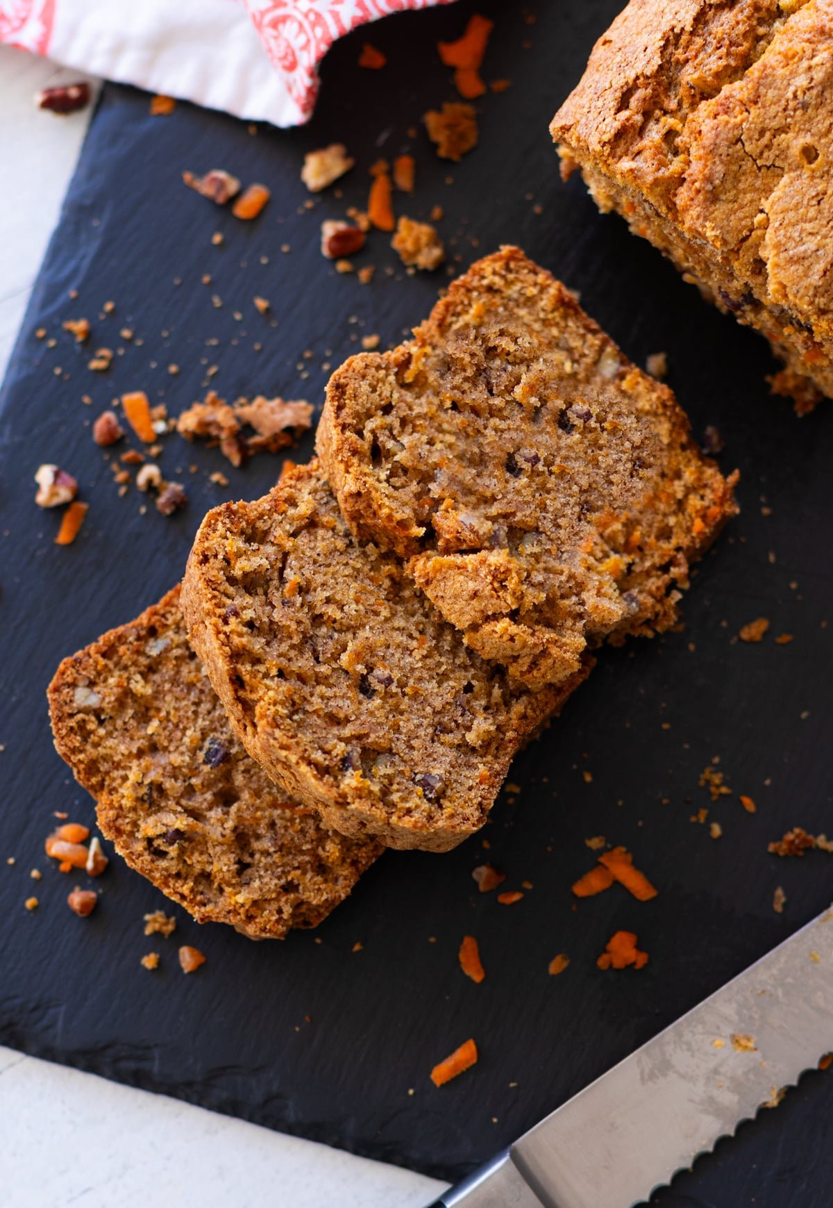3 pieces of sliced carrot cake bread on a cutting board.