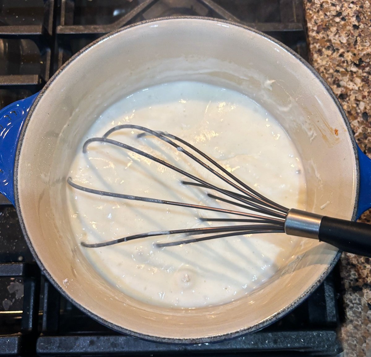 Béchamel Sauce being thickened in a pot.