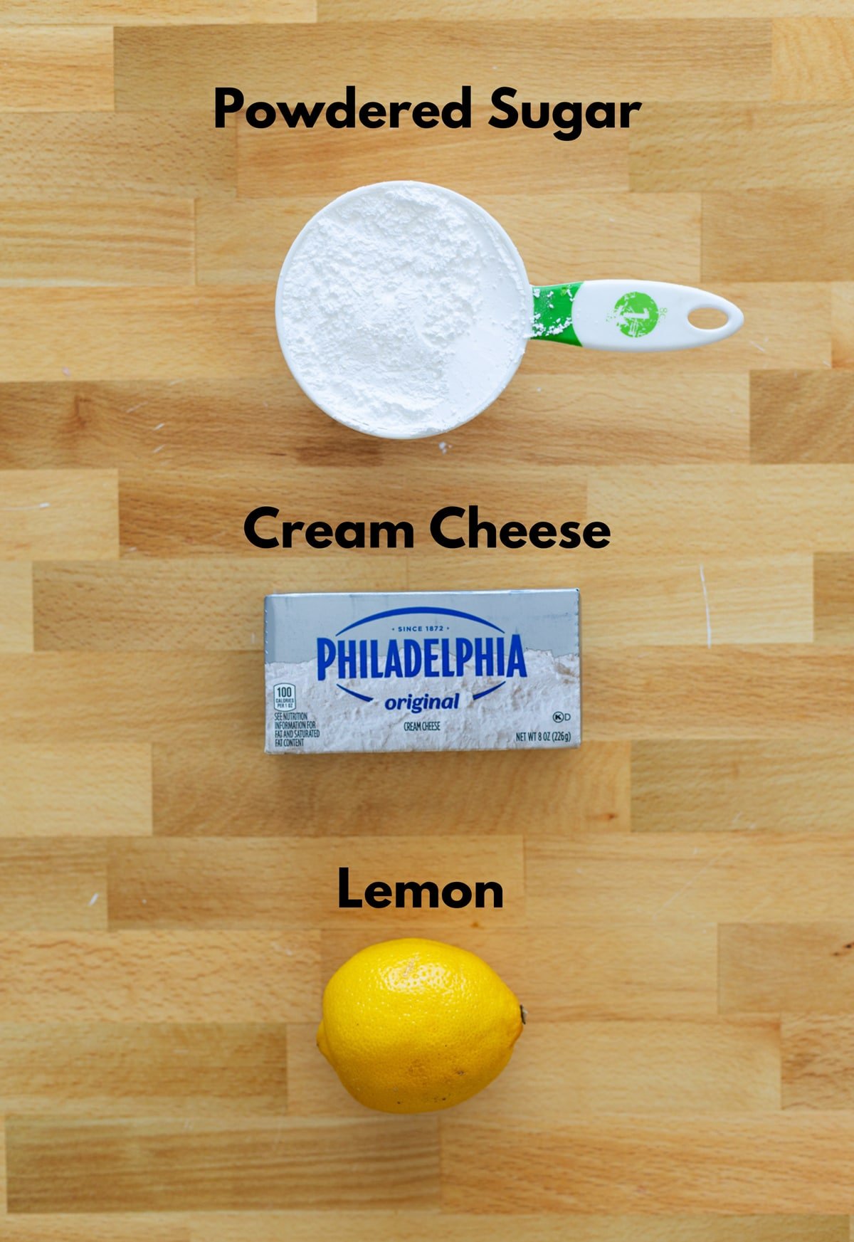 Powdered sugar, cream cheese, and lemon on a counter