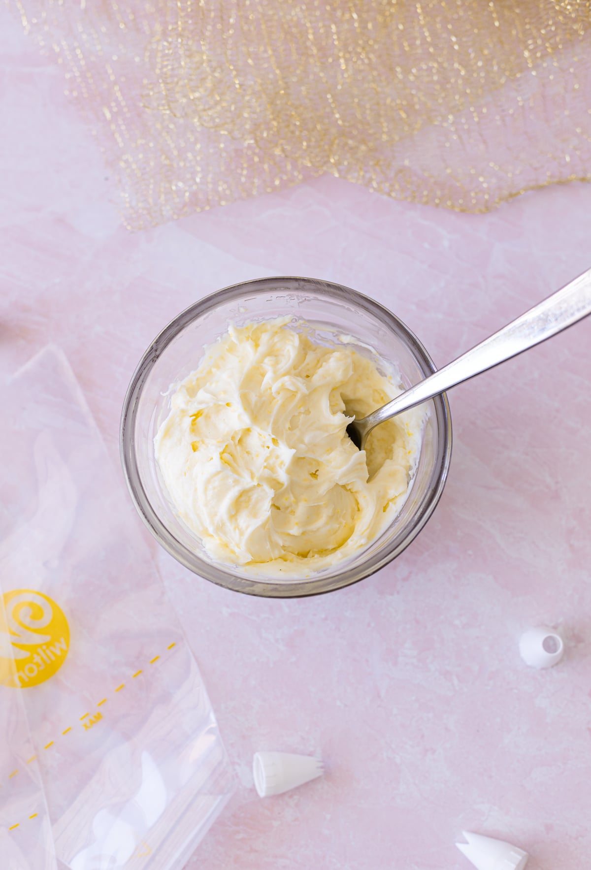 Bowl filled with lemon cream cheese frosting in a bowl on the counter.