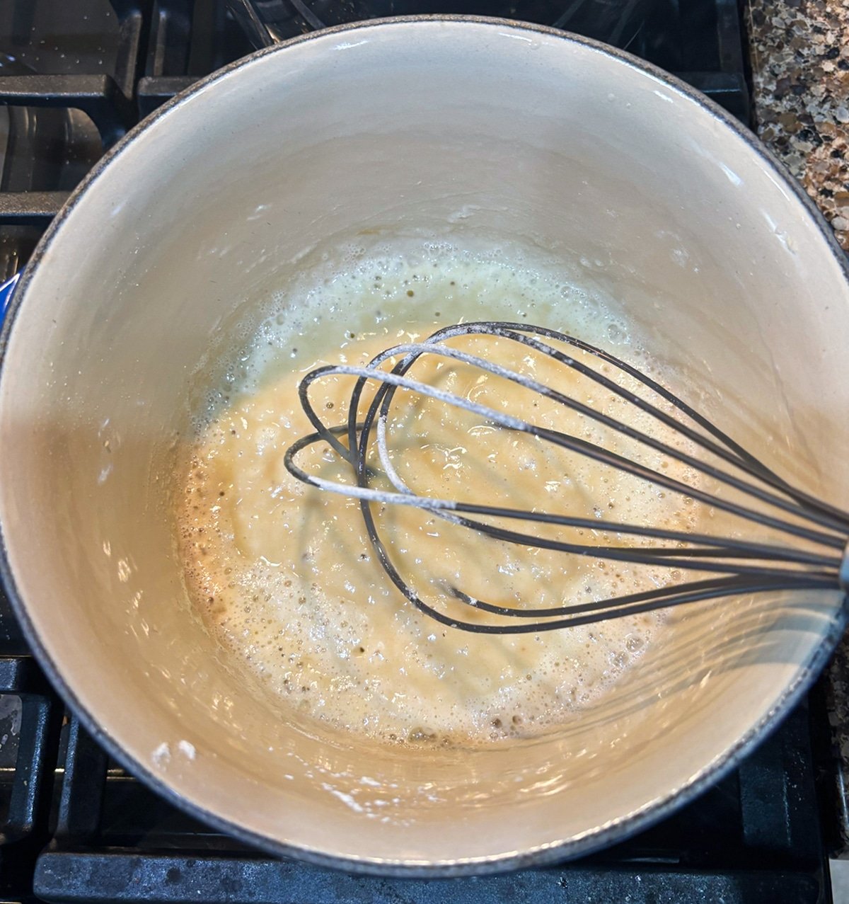 Person making a roux in a saucepan.